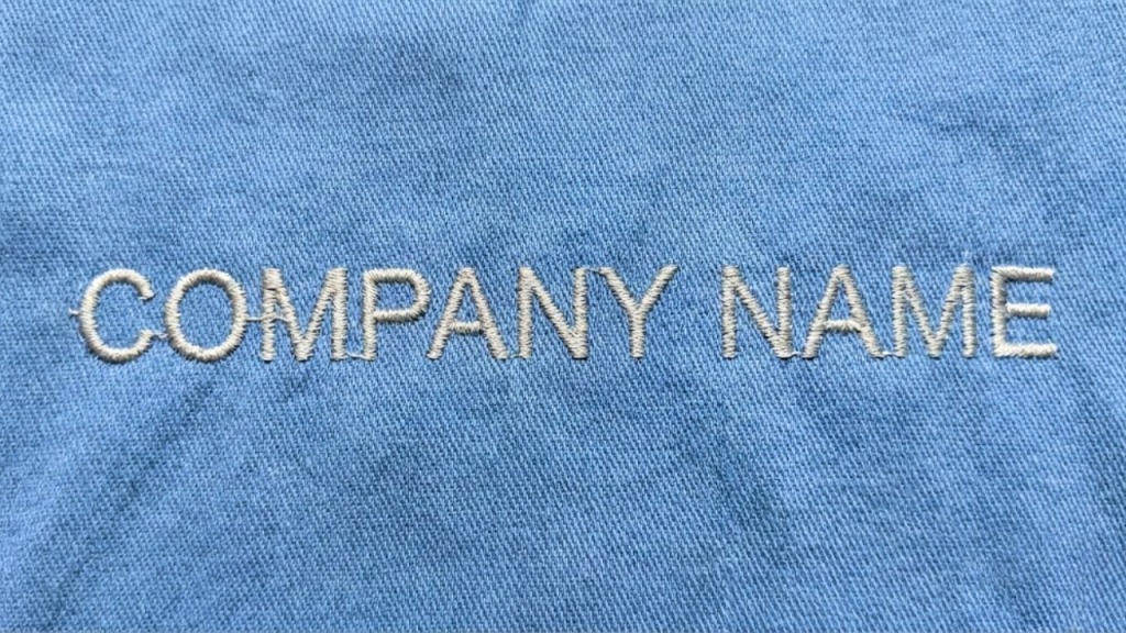 Messy embroidery logo on white fabric with visible jump stitches and loose threads
